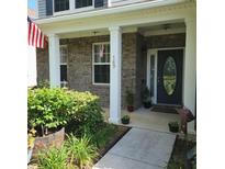 Inviting covered front porch with lush landscaping and American flag at 169 Woodbrook Way, Moncks Corner, SC 29461
