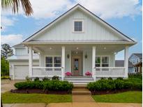Charming, light blue home with a covered front porch, white columns, and manicured landscaping at 1740 Agate Bay Dr, Mount Pleasant, SC 29466