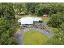 Beautiful aerial view of a charming country home with a white metal roof and a well manicured lawn at 225 Baxter Ln, Walterboro, SC 29488