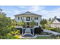 Charming two-story home featuring a double front porch, white columns and professionally landscaped yard at 3011 River Vista Way, Mount Pleasant, SC 29466