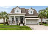Charming two-story home with a covered front porch, brick accents, and a well-manicured lawn and two-car garage at 3726 Orion Ln, Mount Pleasant, SC 29466