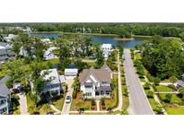 Stunning aerial view of a traditional home with lush landscaping, a pond and community lake views at 3741 Juneberry Ct, Mount Pleasant, SC 29466