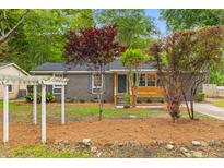 Charming single-story brick home with well-manicured landscaping and inviting front porch at 411 Berkeley Dr, Moncks Corner, SC 29461