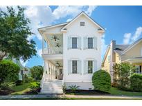 Charming two-story home with a inviting porch and blue shutters on a sunny day at 416 Barbadian Way, Mount Pleasant, SC 29464