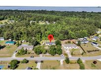 Charming home nestled amongst mature trees with access to the Albemarle Sound at 454 Pooshee Plantation Way, Bonneau, SC 29431