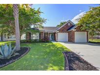 Charming brick home with a well-manicured lawn, mature trees, and a two-car garage at 486 Maple Oak Ln, Charleston, SC 29414
