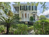 Charming two-story home with a lovely landscaped yard and decorative iron fence at 5 Logan St, Charleston, SC 29401
