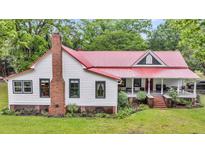 Quaint farmhouse with a red roof, white siding, and a welcoming front porch at 516 Hope Plantation Ln, Jacksonboro, SC 29452