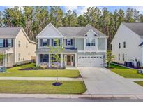Charming two-story home featuring a manicured lawn, inviting porch, and a two-car garage in a Gathering-friendly neighborhood at 596 Dunswell Dr, Summerville, SC 29486