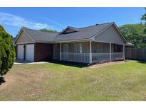 Charming single-story home with a well-maintained lawn and attached two-car garage at 7733 Buck Pond Rd, North Charleston, SC 29418