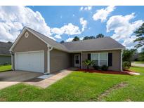 Charming single-story home with neutral siding, attached garage, and manicured front yard with palm tree at 100 Pine Hall Dr, Goose Creek, SC 29445