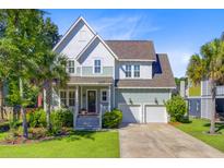 Charming two-story home features a landscaped yard, covered porch, and two-car garage at 104 Wando Reach Rd, Wando, SC 29492