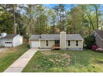Charming single-story home featuring a well-maintained lawn, attached garage, and a cozy front porch entry at 109 Sawmill Dr, Summerville, SC 29483