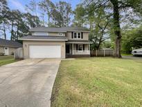 Charming two-story home with a well-manicured lawn and attached two car garage at 123 Lewisfield Dr, North Charleston, SC 29418