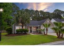 Charming single-story home featuring well-kept landscaping with palm trees and a two-car garage at 1525 Cypress Pointe Dr, Mount Pleasant, SC 29466
