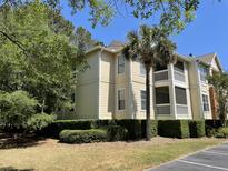 Attractive condo building featuring screened porches, manicured landscaping and a palm tree at 1600 Long Grove Dr # 411, Mount Pleasant, SC 29464