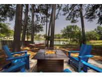 Inviting backyard with fire pit, adirondack chairs, hammock, and tranquil lake views at 1709 Blalock St, Mount Pleasant, SC 29466