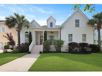 Charming two-story white home featuring a beautifully landscaped yard and inviting front porch at 2141 Sandy Point Ln, Mount Pleasant, SC 29466