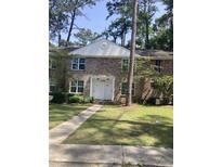 Traditional brick townhouse with a well-manicured lawn and mature trees offers a welcoming curb appeal at 306 Crestview Dr # C, Summerville, SC 29485