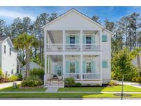Charming two-story home with double porches, complemented by lush landscaping and classic white facade at 4114 Maidstone Dr, Mount Pleasant, SC 29466