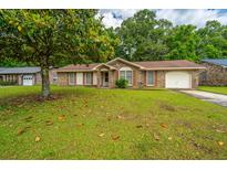 Traditional single story home with brick and vinyl siding, a front yard, and an attached garage at 4328 Cheviot Dr, North Charleston, SC 29418