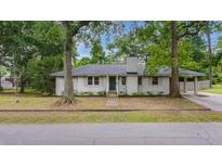 Charming single-story white brick home with mature trees, inviting entrance, and a well-manicured front yard at 4924 France Ave, North Charleston, SC 29405