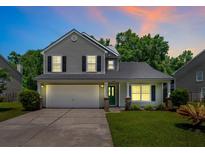 Charming two-story home featuring a well-manicured lawn, two car garage and beautiful, mature landscaping at 4977 Ballantine Dr, Summerville, SC 29485