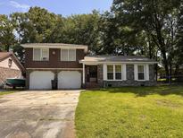 Charming two-story brick home with a well-manicured lawn and a two-car garage nestled among mature trees at 5 Apple Cir, Goose Creek, SC 29445
