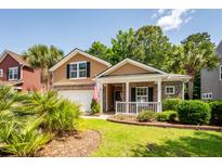 Charming two-story home with brick accents, front porch, attached garage, and manicured lawn at 5002 W Liberty Meadows Dr, Summerville, SC 29485