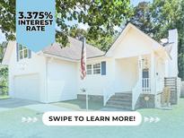 Charming white two-story home with well-maintained lawn and inviting front porch at 5052 Hidden Forest Ln, North Charleston, SC 29420