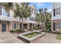 Charming multi-story townhome featuring brick accents, palm trees, and a lovely water fountain at 656 Coleman Blvd # 703, Mount Pleasant, SC 29464
