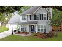 Charming two-story home with symmetrical design, black shutters and a well-manicured lawn and garden at 709 Black Oak Blvd, Summerville, SC 29485