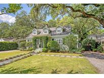 Charming green home with lush landscaping and mature trees providing ample shade at 735 Woodward Rd, Charleston, SC 29407