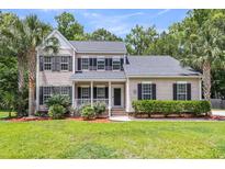Charming two-story home with a welcoming porch and well-maintained landscaping at 8166 Scottswood Dr, North Charleston, SC 29418