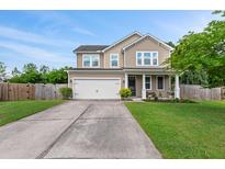 Charming two-story home features a well-manicured lawn, attached two-car garage, and inviting front porch at 111 Gavins Way, Goose Creek, SC 29445