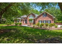 Charming brick home with manicured lawn, mature trees, and inviting entrance at 121 Arrowridge Ct, Summerville, SC 29485