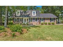 Charming two-story brick home with a well-manicured lawn, black shutters, and dormer windows at 122 Mellard Dr, Goose Creek, SC 29445