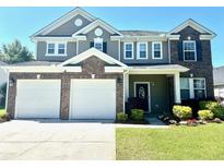 Beautiful two-story home featuring a two-car garage, brick accents, and a well-manicured lawn at 1333 Song Sparrow Way, Hanahan, SC 29410