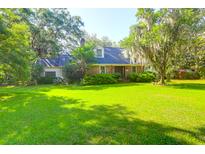 Charming brick home with lush green lawn and mature trees creating a peaceful curb appeal at 1521 Wren Ave, Mount Pleasant, SC 29464