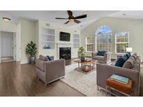 Bright living room features a ceiling fan, fireplace, hardwood floors, and a large window at 1631 Camfield Ln, Mount Pleasant, SC 29466