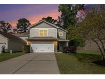 Charming two-story home featuring stone accents, a two-car garage, and a well-manicured front yard at 1723 Indaba Way, Charleston, SC 29414