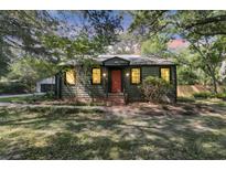 Charming home with a red front door and mature landscaping that provides excellent shade at 1730 Harrison Ave, Charleston, SC 29407