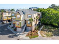 A multi-story home with a two car garage, stairs leading to the main floor, and lovely palm trees at 204 Michigan Ave B3 # 16, Folly Beach, SC 29439