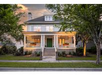 Charming two-story home features a welcoming porch with white columns and a green front door at 2431 Settlers St, Charleston, SC 29492