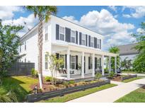 Charming two-story home featuring a welcoming front porch, swing, and well-manicured lawn at 262 Great Lawn Dr, Summerville, SC 29486