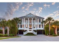 Stately two-story home featuring a welcoming front porch with columns, dual garage doors, and manicured landscaping at 2705 Parkers Landing Rd, Mount Pleasant, SC 29466