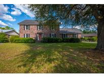Charming two-story brick home with a well-manicured lawn and mature trees at 305 Whitewood Ct, Moncks Corner, SC 29461