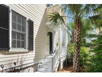 Charming home entrance with white stairs, black door, palm tree, and well-maintained landscaping at 34 Dereef Ct, Charleston, SC 29403