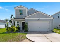 Charming two-story home with a two-car garage, landscaping, and a light gray exterior at 630 Jancus St, Charleston, SC 29414