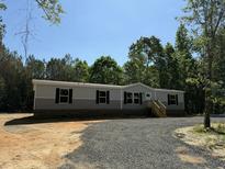 Charming home featuring gray siding, black shutters and a well-maintained landscaped yard at 846 Lawyer Ln, Cross, SC 29436